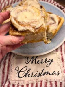 hand picking up a cinnamon roll