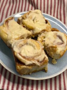 4 cinnamon rolls on a blue plate 